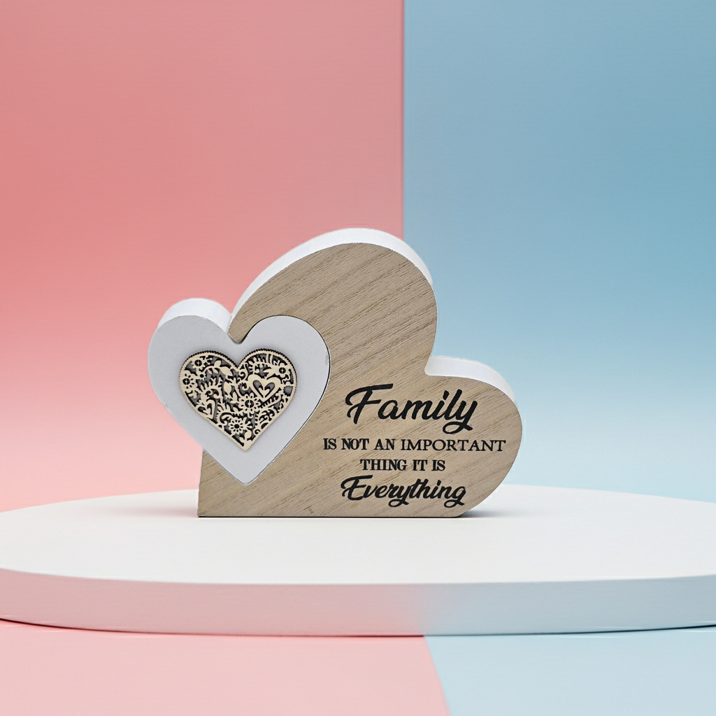 Wooden heart-shaped decorative piece with text "Family is not an important thing it is everything" on a two-tone pink and blue background