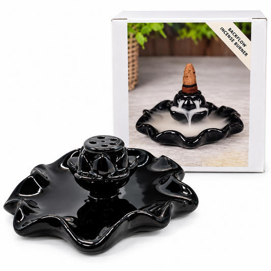 Black flow incense burner with a wavy dish-shaped base and central incense holder, shown in front of its white retail box on a clean white background.