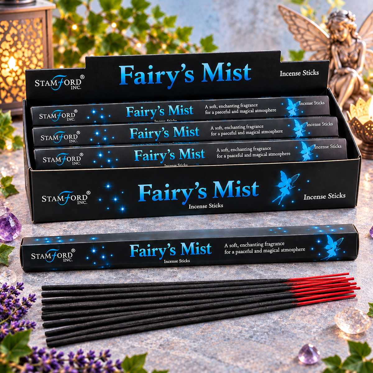 Five boxes of Stamford Inc. Fairy's Mist incense sticks arranged on a stone surface, with several black incense sticks and a few red-tipped incense sticks placed in front.