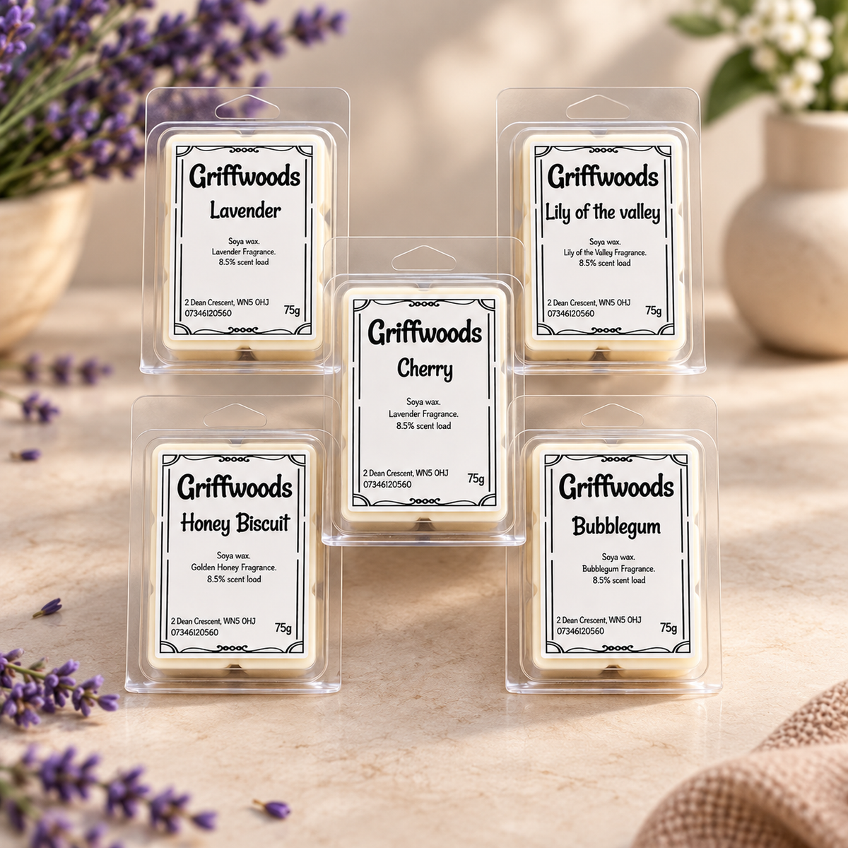 Five Griffwoods scented wax melts in clear clamshell packaging arranged on a light stone surface. The labels show different fragrance names: Lavender, Lily of the valley, Cherry, Honey Biscuit, and Bubblegum.
