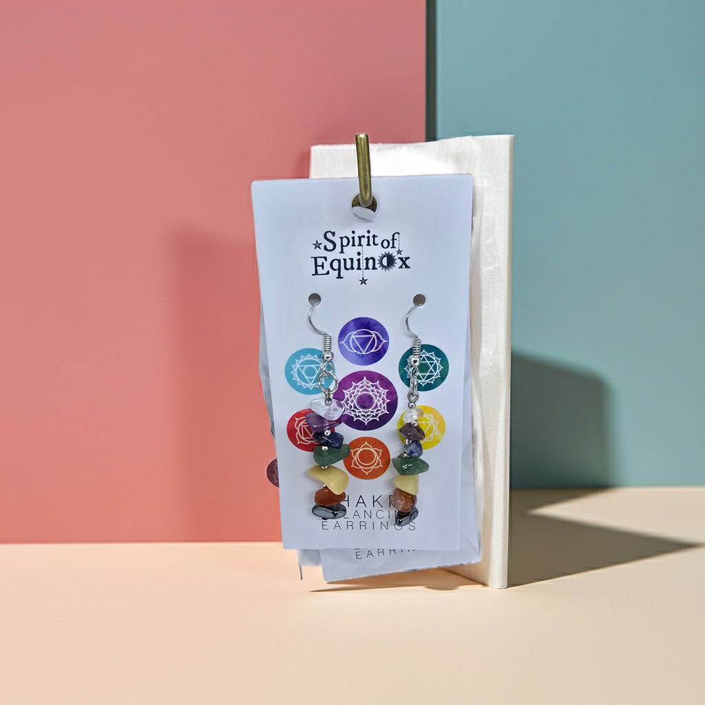 Chakra balance earrings on a 'Spirit of Equinox' branded card against a colorful background