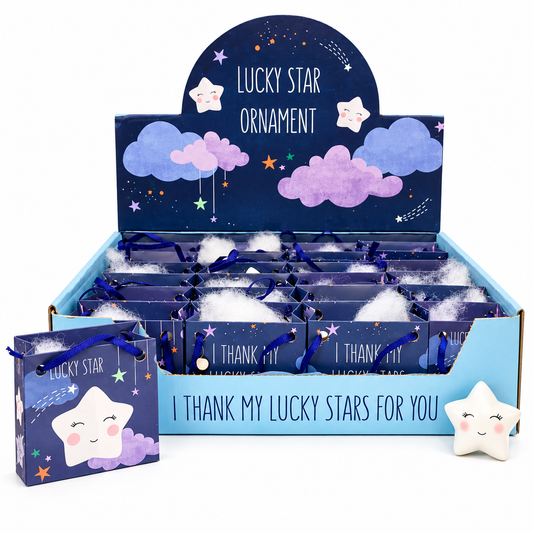 A retail display box and matching small gift bag for a 'Lucky Star Ornament' product. The packaging features a dark blue starry sky design with purple clouds, white stars, and the text 'Lucky Star Ornament' and 'I THANK MY LUCKY STARS FOR YOU'.