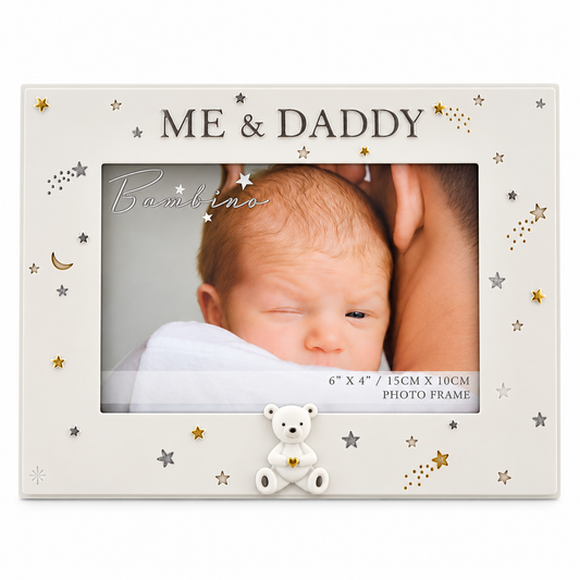 An off-white personalized baby photo frame with 'ME & DADDY' printed at the top, decorated with gold and silver stars, moons, and shooting stars. A small white teddy bear sits at the bottom center, holding a tiny gold star.