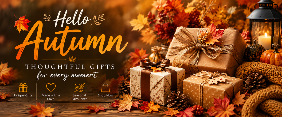 Promotional autumn-themed banner with the text 'Hello Autumn' and 'Thoughtful Gifts for every moment' over a styled scene of wrapped gift boxes, fall leaves, pinecones, a candle lantern, and knitted fabric on a wooden surface.