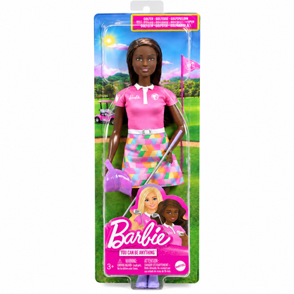 Barbie golf doll in retail packaging, featuring a dark-skinned female doll wearing a pink polo shirt and a colorful geometric skirt, holding a golf club and watering can on a golf course backdrop.