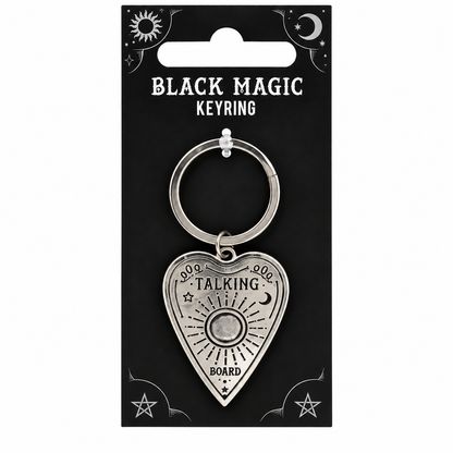 A silver metal keyring with a heart-shaped pendant featuring a board game board design and the words 'TALKING BOARD' and '4000', displayed on a black backing card labeled 'BLACK MAGIC KEYRING'.