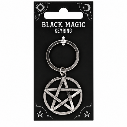 A silver-toned metal keyring with a pentagram pendant, mounted on a black retail card labeled 'BLACK MAGIC KEYRING' with moon and star graphics.