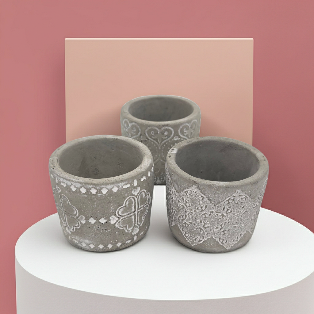 Three decorative concrete Candle Holders with intricate patterns on a white platform against a multicolored background.