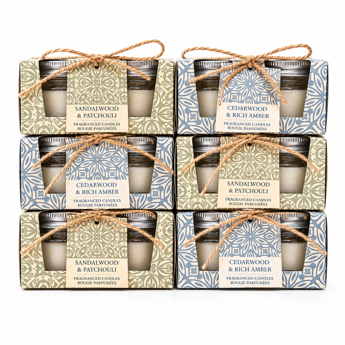 Six boxed scented candles arranged in a 3-by-2 grid on a white background. Each package contains two small glass jar candles tied with twine and a front label reading either Sandalwood & Patchouli or Cedarwood & Rich Amber.