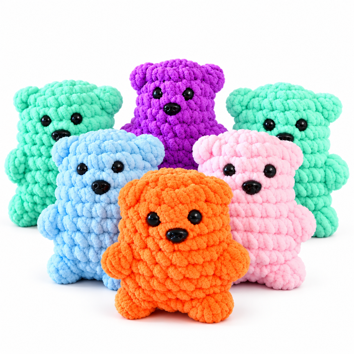 Six crocheted teddy bear toys in assorted colors, including mint green, purple, light blue, pink, and orange, arranged together on a plain white background.