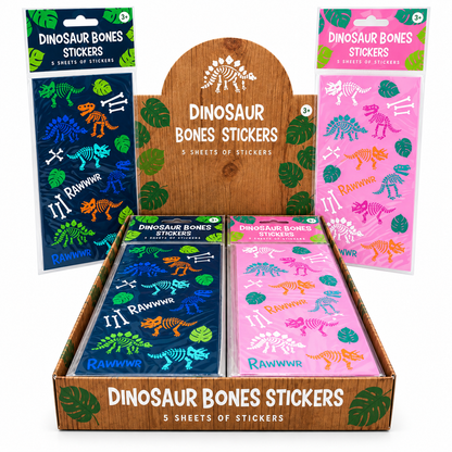A retail display box filled with dinosaur bones stickers in two colorways: a dark blue pack with green and orange bones, and a pink pack with purple, blue, and orange bones. Two additional sealed packs stand behind the display, one dark blue and one pink.