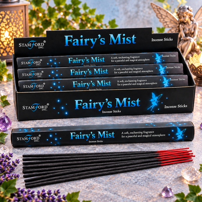 Five boxes of Stamford Inc. Fairy's Mist incense sticks arranged on a stone surface, with several black incense sticks and a few red-tipped incense sticks placed in front.