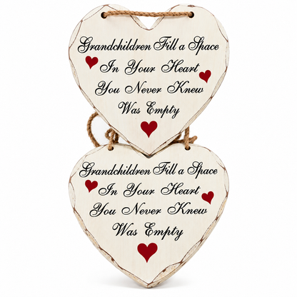 Two stacked heart-shaped wooden hanging plaques with rustic distressed edges, printed with the quote 'Grandchildren Fill a Space In Your Heart You Never Knew Was Empty' in black script, accented with small red hearts, shown on a white background.