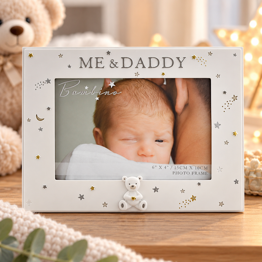 A personalized baby photo frame with a white background, decorated with gold and silver stars, moons, and the text 'ME & DADDY' at the top. A small white teddy bear sits at the bottom center.