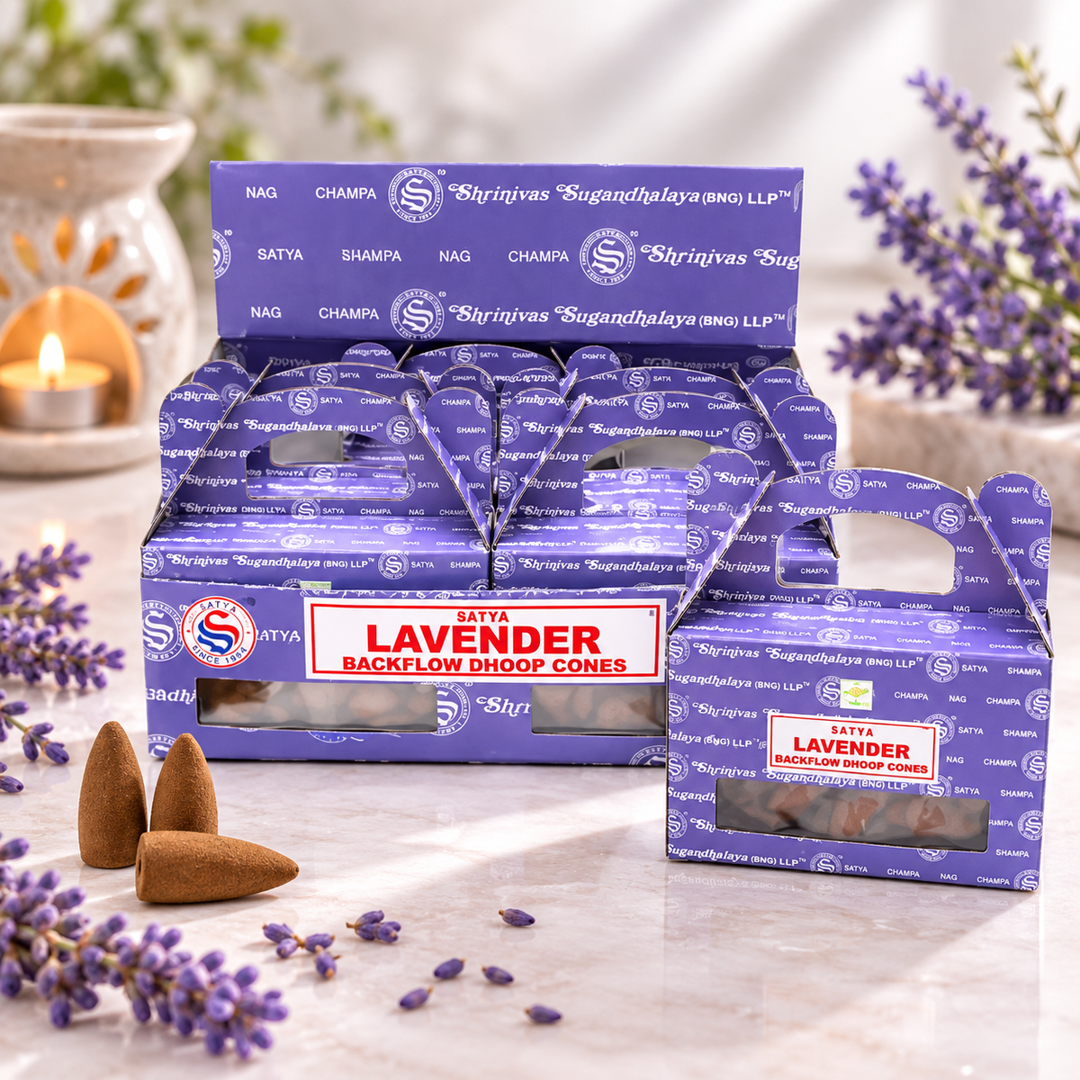 A retail display box and individual package of Taita Lavender Backflow Dhoop Cones, shown with lavender sprigs and a lit candle on a marble surface.