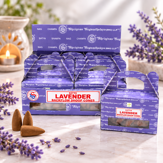 A retail display box and individual package of Taita Lavender Backflow Dhoop Cones, shown with lavender sprigs and a lit candle on a marble surface.
