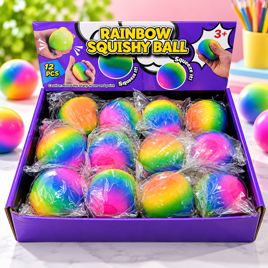 A purple box of 12 rainbow-colored squishy balls, each individually wrapped in clear plastic, displayed on a light surface with additional balls scattered around.