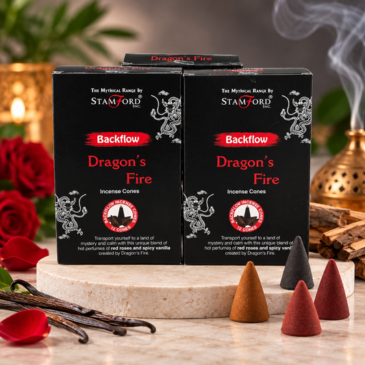 Two black boxes of Stamford Backflow Dragon's Fire incense cones displayed on a marble slab with vanilla beans, rose petals, and lit incense sticks in a warm, atmospheric setting.