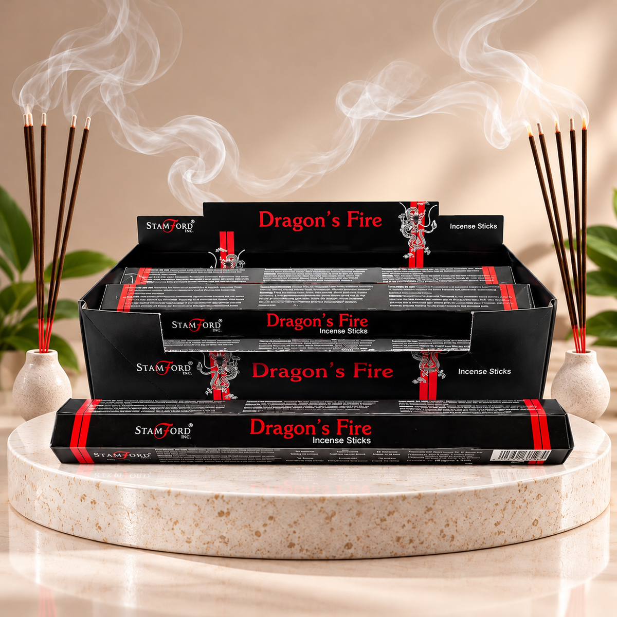 Five boxes of STAMFORD Dragon's Fire incense sticks arranged in a display tray on a round stone pedestal, with incense sticks and smoke rising in a styled setting.