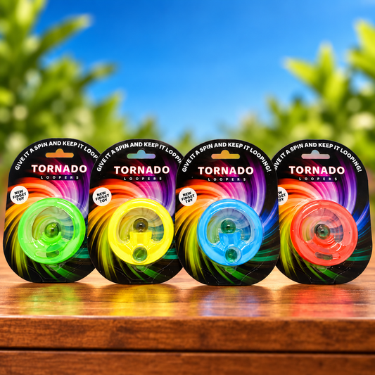 Four packaged Tornado Loopers standing side by side on a wooden surface with a blurred outdoor background of blue sky and green leaves. The packages show different loop colors: green, yellow, blue, and orange.