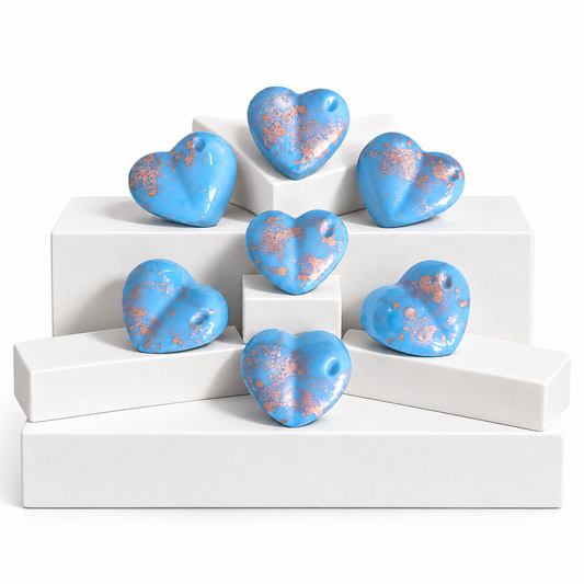 Seven glossy light blue heart-shaped Wax Melts, arranged on white display blocks against a white background.
