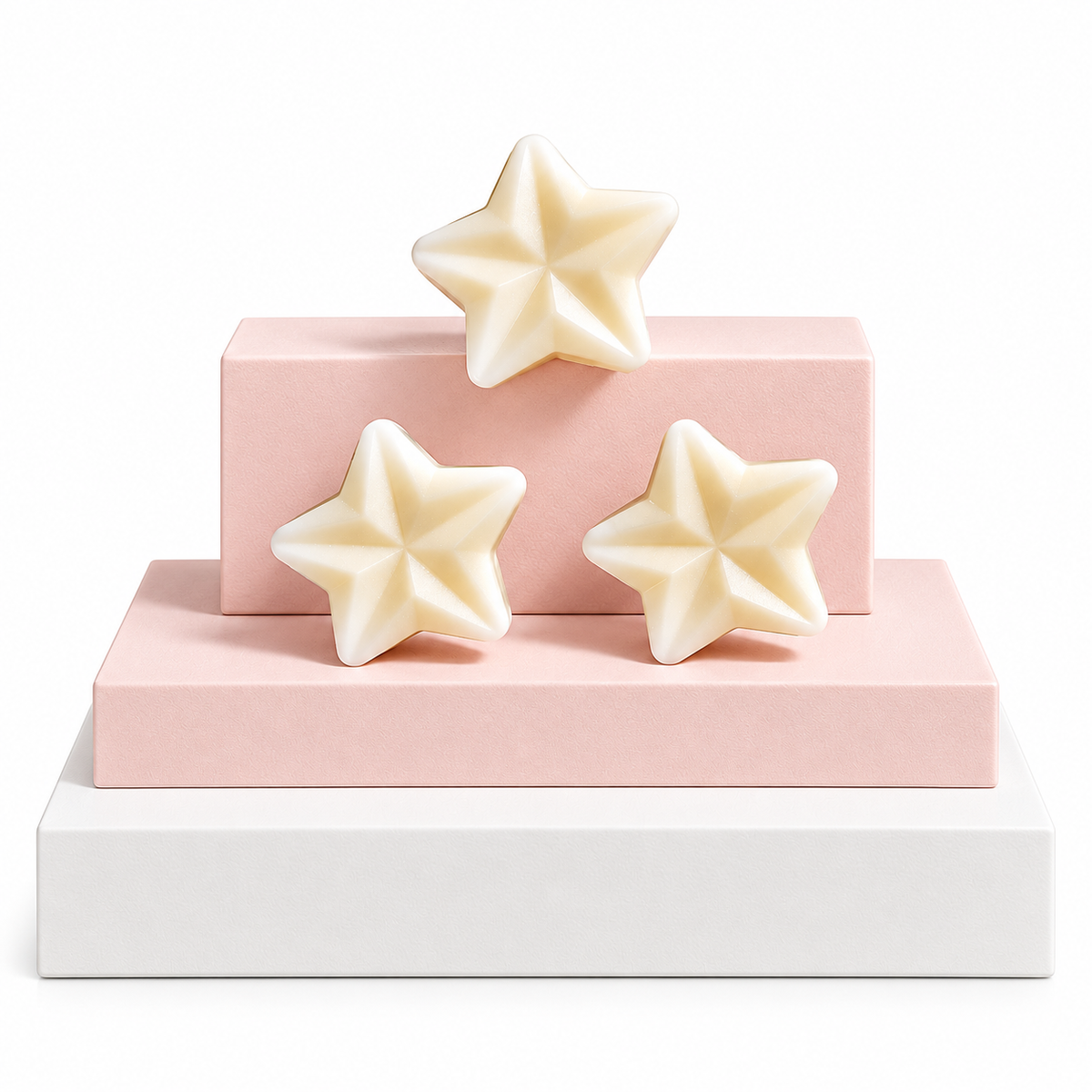 Three cream-colored star-shaped wax melts arranged on a two-tiered pink and white display pedestal against a white background.