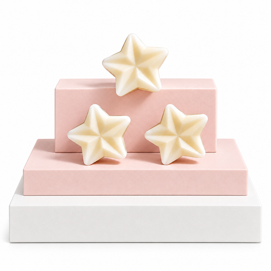 Three cream-colored star-shaped wax melts arranged on a two-tiered pink and white display pedestal against a white background.