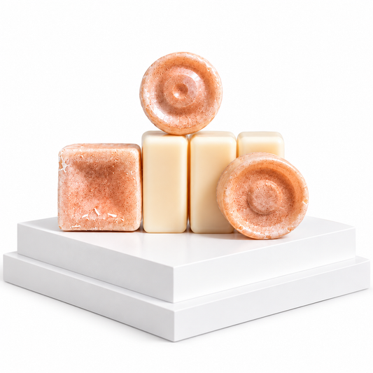 Three handmade sWax melts in two shades of peach and cream, arranged on a white tiered pedestal against a white background.