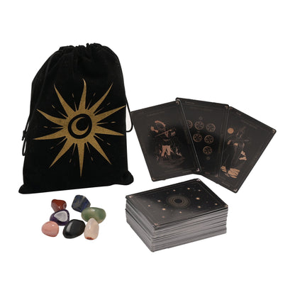 Set of tarot cards with a black drawstring bag featuring a sun design, and a stack of stones on a white background.