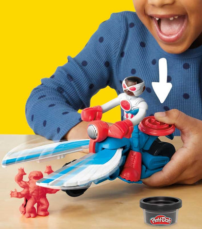 Child playing with a toy figure on a yellow background, with Play-Doh container visible.
