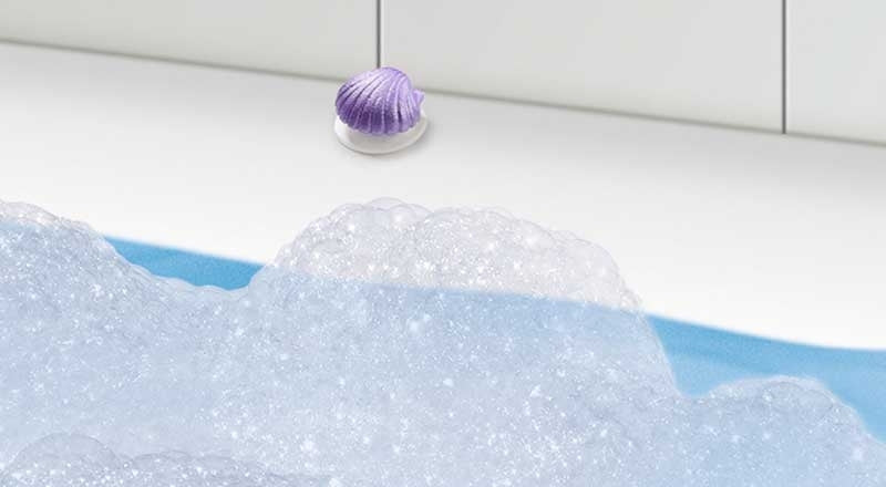Purple bath bomb with bubbles in a bathtub