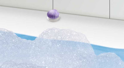 Purple bath bomb with bubbles in a bathtub